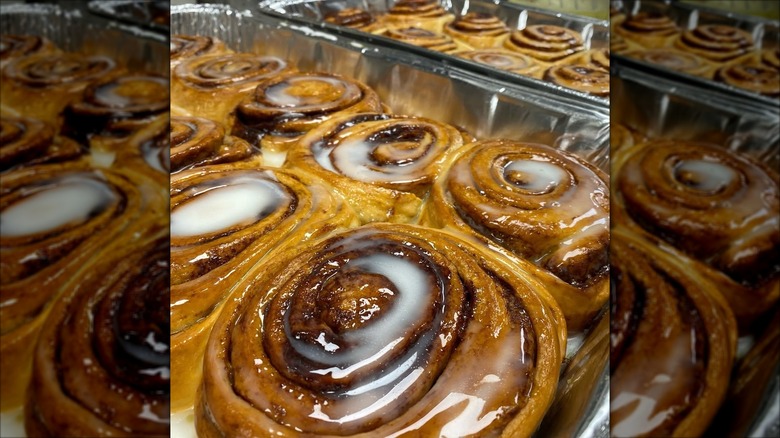 Glazed cinnamon rolls in baking tins