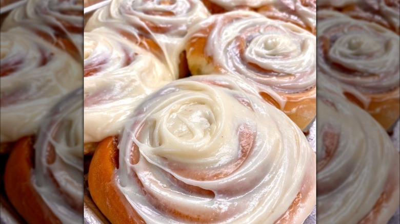 Frosted cinnamon rolls on baking sheet