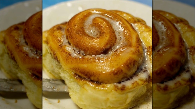 Single glazed cinnamon roll on plate