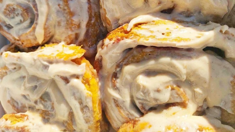 Several frosted cinnamon rolls dappled in sunlight