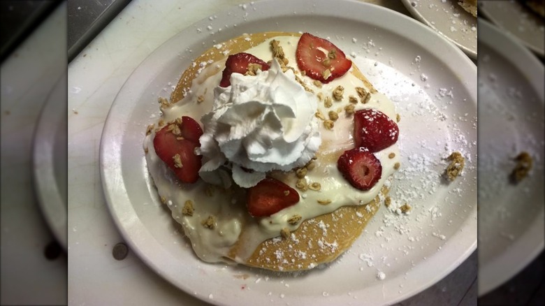 Top-down view of strawberry cream cheese pancakes on white plate