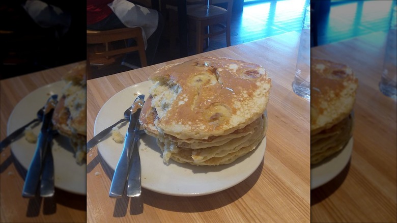 Stack of banana peanut butter pancakes on white plate