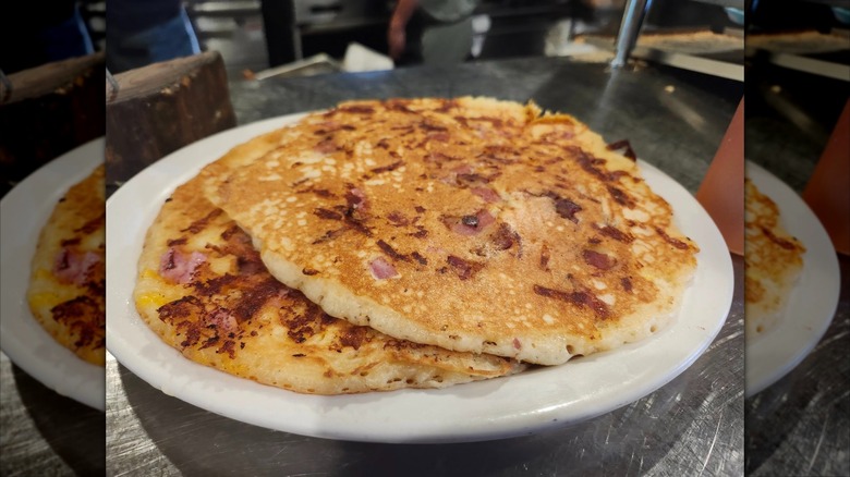 Stack of ham and cheese pancakes on white plate