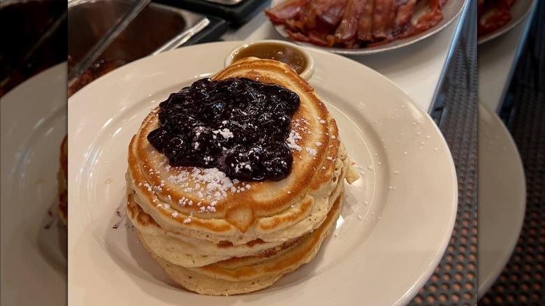 Stack of blueberry pancakes on white plate