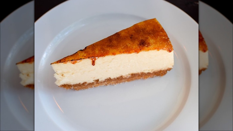 Slice of cheesecake with brulee top on white plate