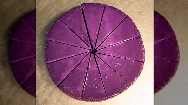 Top-down shot of sliced ube cheesecake on wooden table