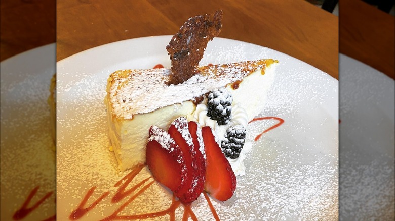 Slice of cheesecake and berries on white plate