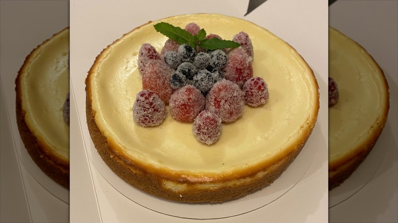 Cheesecake with sugared raspberries and blueberries on top