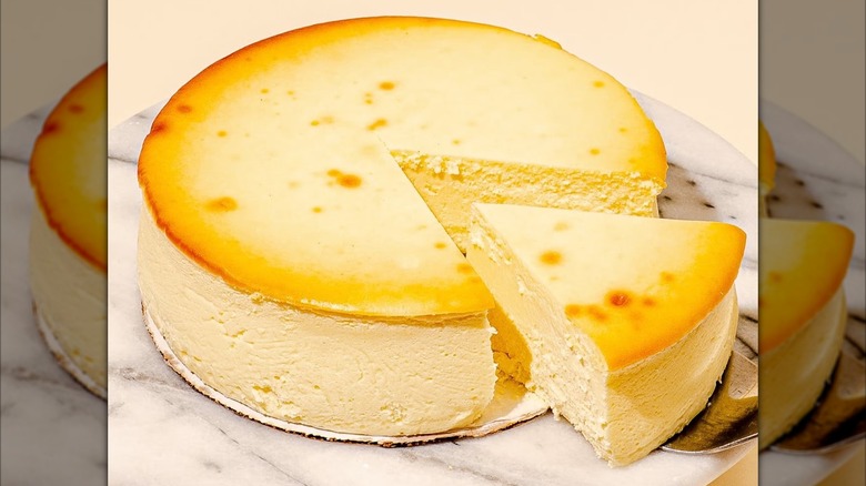 Plain cheesecake with slice taken out of it