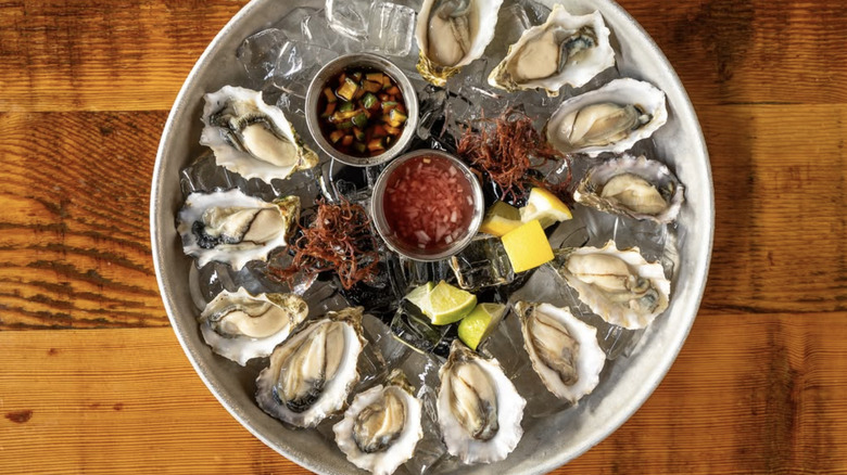Platter of oysters with sauces and lemon