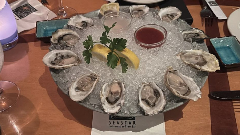 Platter of oysters and ice on a wooden table