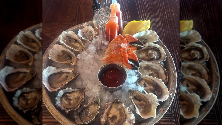 Platter of oysters with condiments on ice