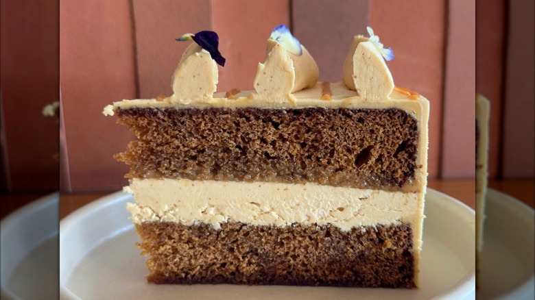 Burnt honey cake on plate topped with three peaks of icing