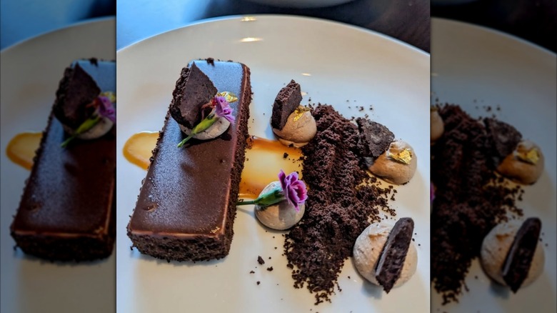 Chocolate cake with edible flowers on plate