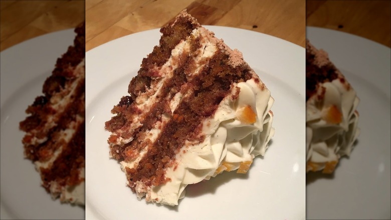Slice of carrot cake with mousse on plate
