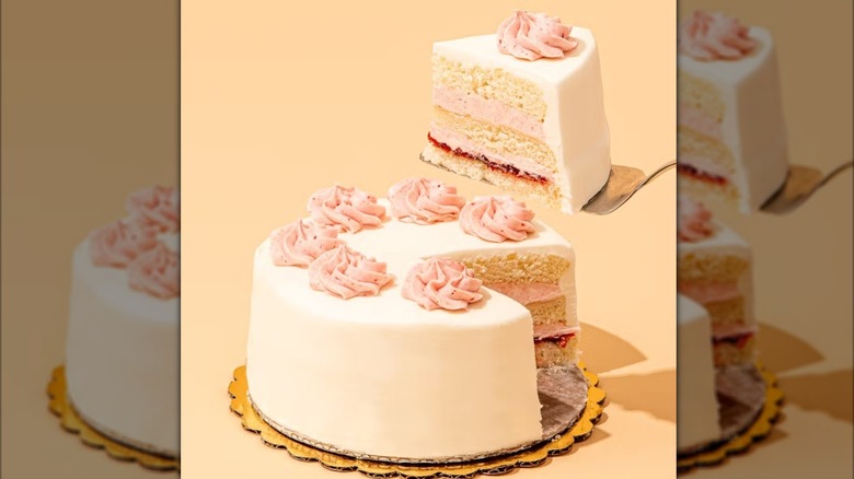 Slice being served from white cake with raspberry preserves and buttercream