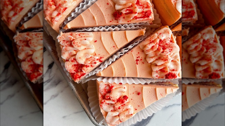 Several slices of raspberry rose cake on marble countertop