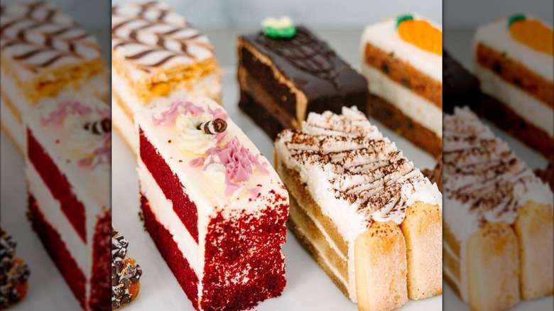 Several varieties of cake in rectangular slices, including red velvet and tiramisu