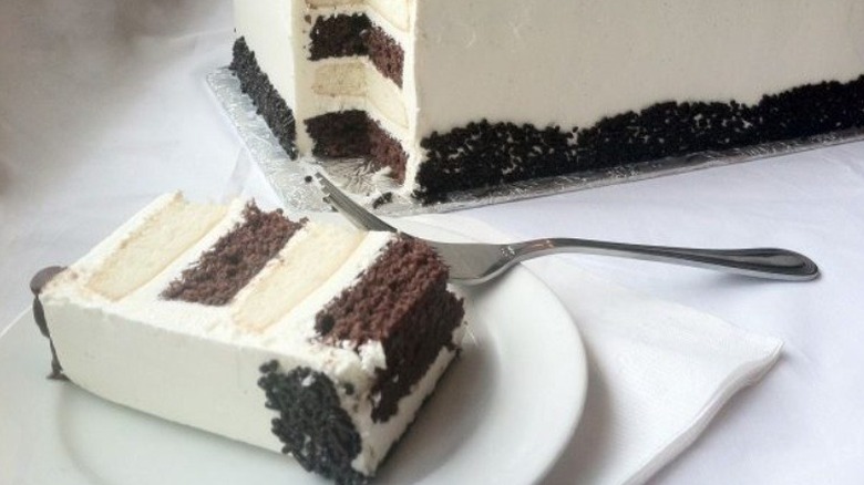 Slice of zebra cake on plate in front of rectangular whole cake
