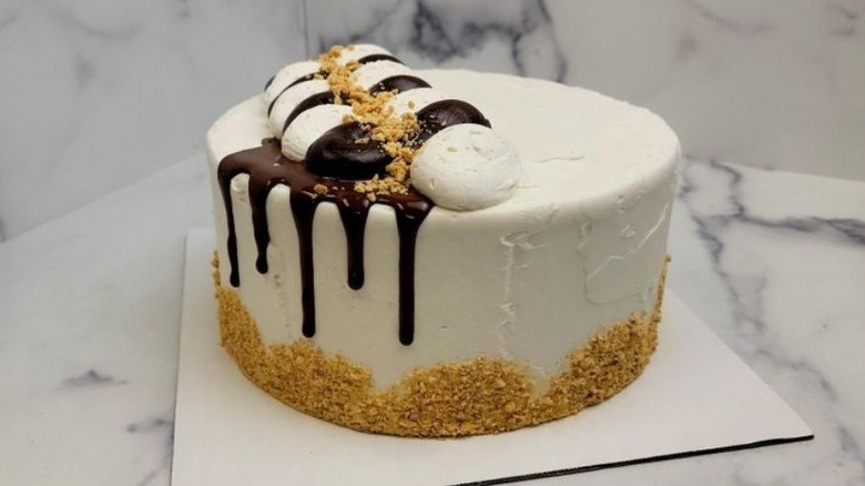 Whole s'mores supreme cake decorated with graham cracker crumbs and chocolate