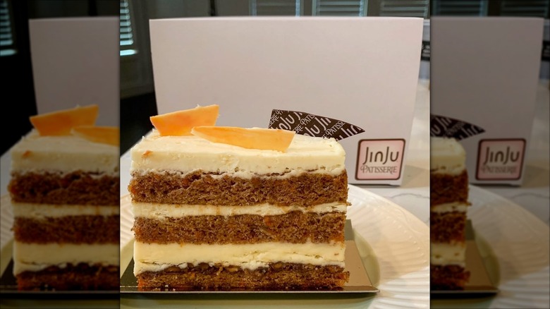Three layered carrot cake with JinJu Patisserie box in background