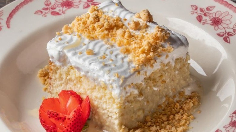 Tres leches cake square with strawberry garnish