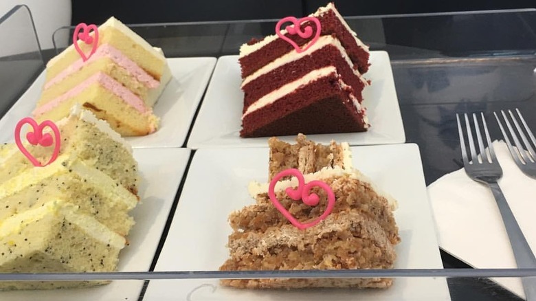Four cake slices prepared for tasting next to two forks