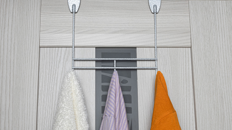 Over-the-door towel hanger with three hooks and a variety of towels hanging from each hook