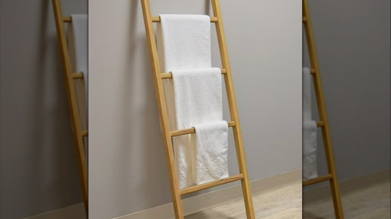 A towel ladder leaning against a neutral colored wall
