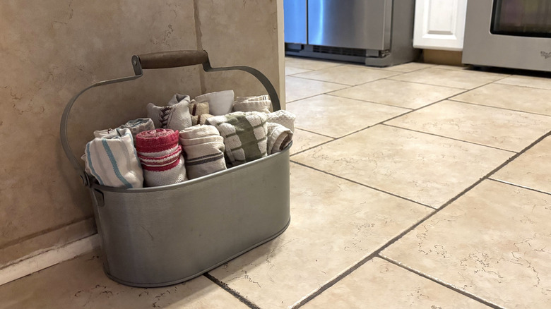 Marble floor with a wine holder being used to organize kitchen towels