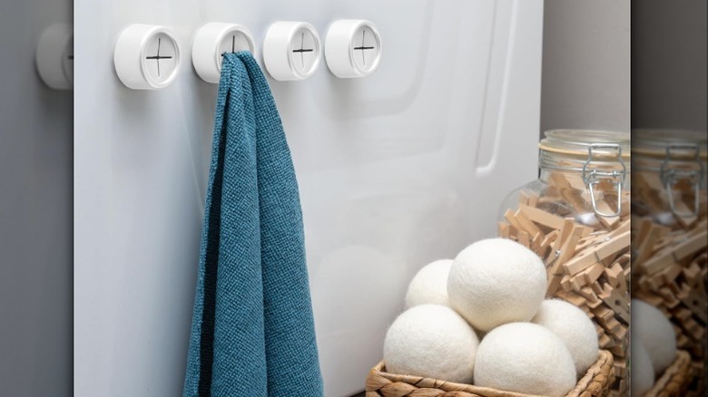 Push towel holders with one holding a teal towel