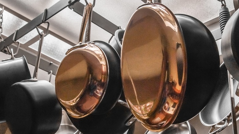 Copper and iron pans hanging on racks