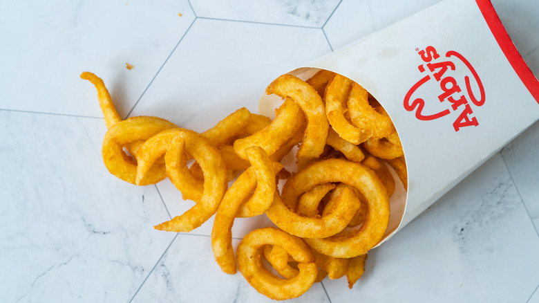 Sleeve of Arby's fries on hexagonal tiles