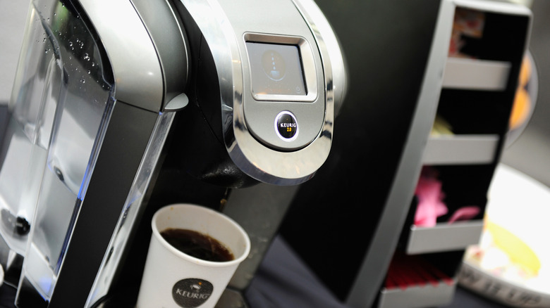 View of Keurig coffee machine brewing cup of coffee