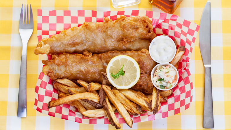 fish and chips in a basket topped with lemon