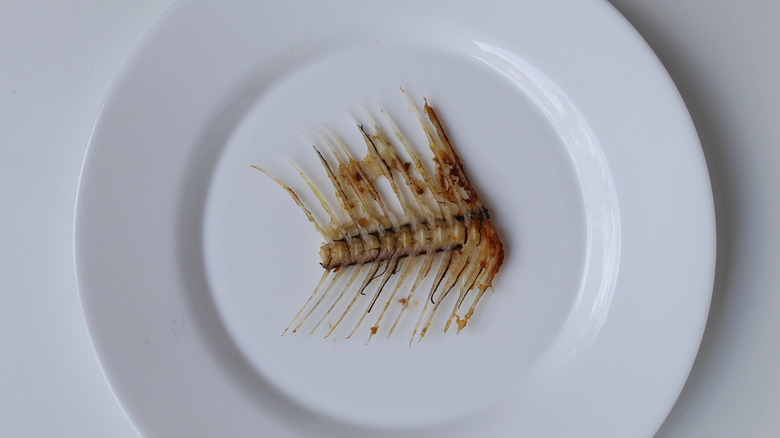 A segment of a a fish skeleton on a white plate