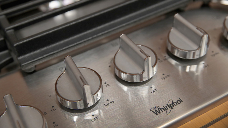 Close-up of stainless steel Whirlpool stove buttons.