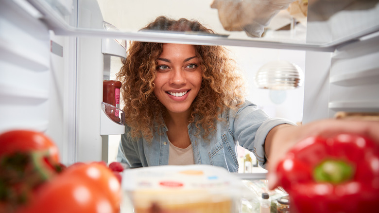 Woman looking into refrigerator