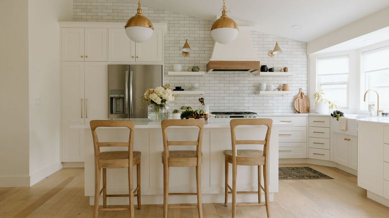 White kitchen with wooden bar chairs and accents