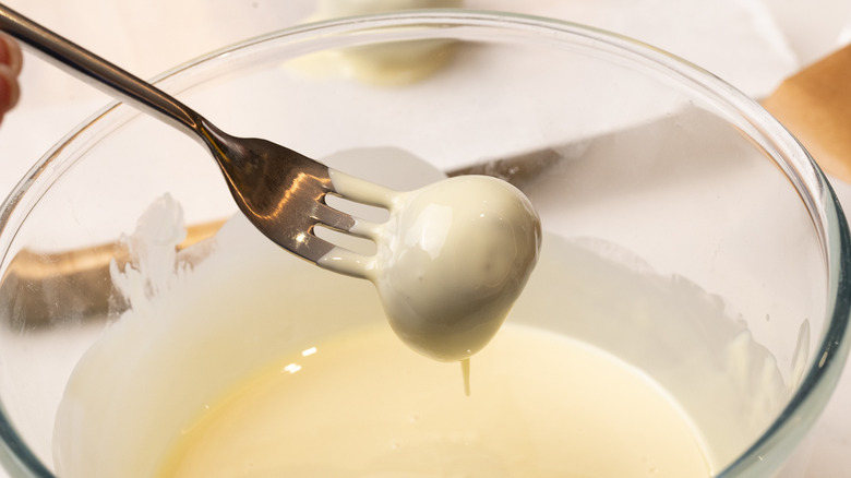 dipping cookie balls into chocolate