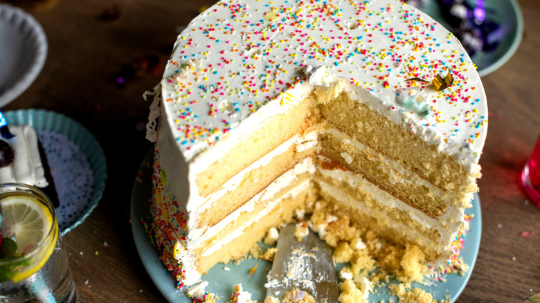 Slicing into a layer cake on a stand
