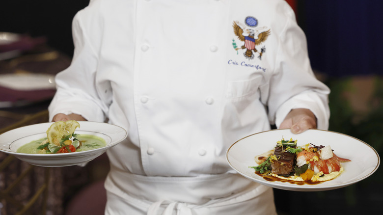 A White House chef holding two plates of food