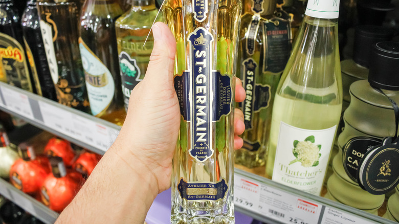 holding St-Germain liqueur bottle
