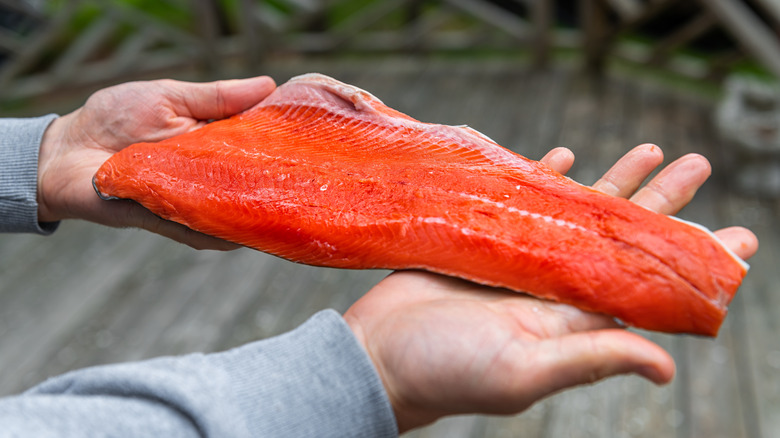 man holding salmon fillet