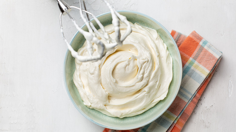 Overhead view of mixer whipping up heavy cream in a bowl