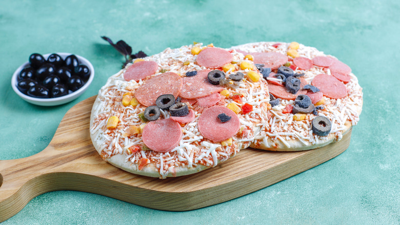 frozen pizzas on wooden tray