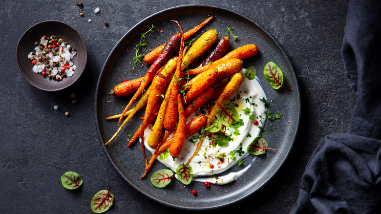 Overhead view of roasted carrots atop creamy yogurt sauce