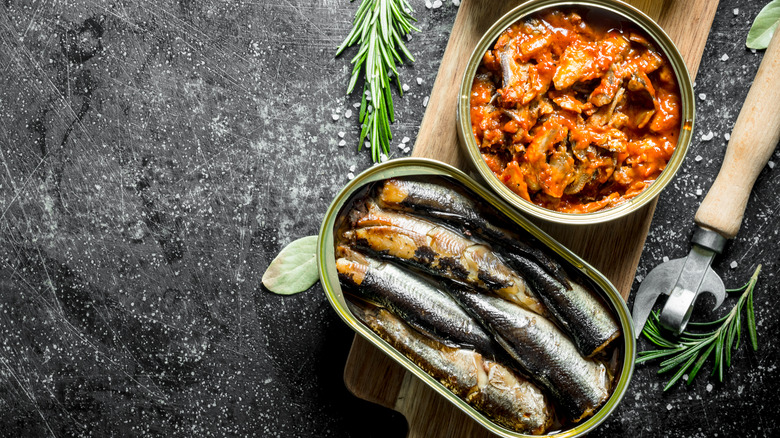 canned fish on a wooden board