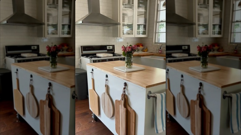 workbench in kitchen as island with chopping boards hanging on the side