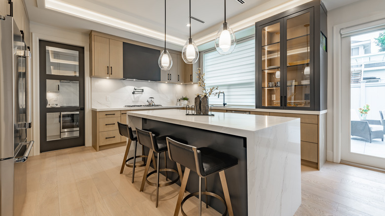 A kitchen with an island and black chairs